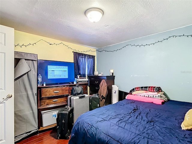 bedroom featuring wood finished floors and a textured ceiling
