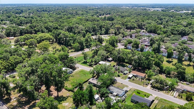aerial overview of property's location featuring a forest and nearby suburban area