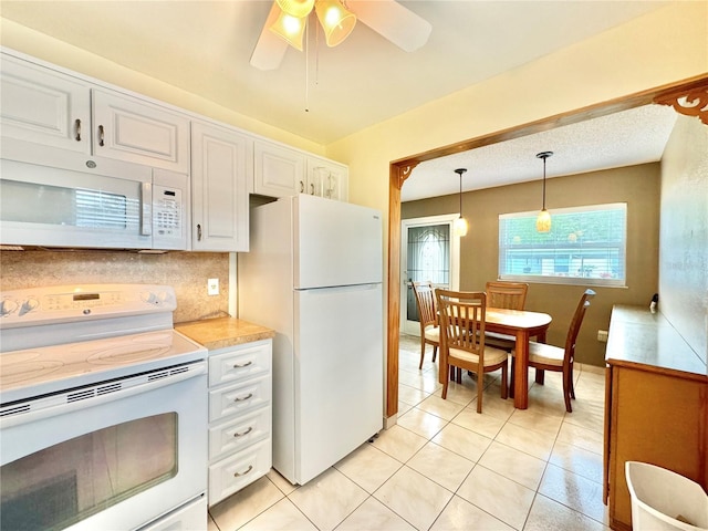 11619 Boynton Ln, New Port Richey, FL 34654 - kitchen featuring white appliances, white cabinets, light countertops, hanging light fixtures, and a ceiling fan