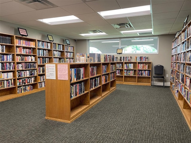 11619 Boynton Ln, New Port Richey, FL 34654 - misc room with wall of books, carpet floors, and a drop ceiling