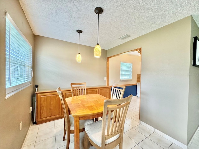 11619 Boynton Ln, New Port Richey, FL 34654 - dining space featuring a textured ceiling and light tile patterned floors
