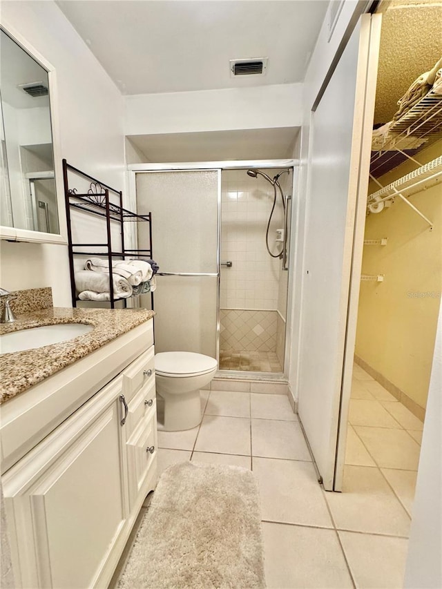 11619 Boynton Ln, New Port Richey, FL 34654 - bathroom featuring vanity, tile patterned floors, a shower stall, and a walk in closet
