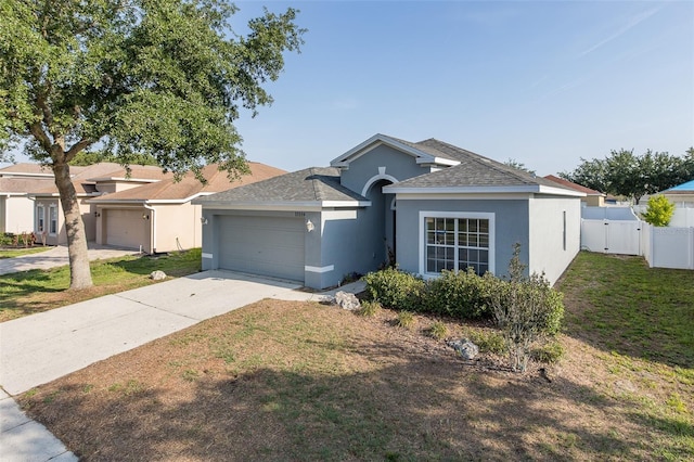 15159 Durango Cir, Brooksville, FL 34604 - ranch-style house featuring stucco siding, an attached garage, concrete driveway, a shingled roof, and a gate
