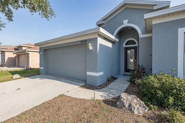 15159 Durango Cir, Brooksville, FL 34604 - ranch-style house featuring a garage, stucco siding, and concrete driveway
