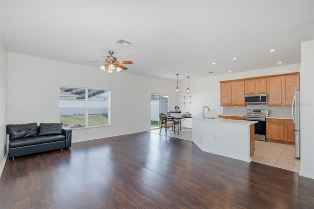 15159 Durango Cir, Brooksville, FL 34604 - kitchen featuring stainless steel appliances, open floor plan, a sink, ceiling fan, and light countertops