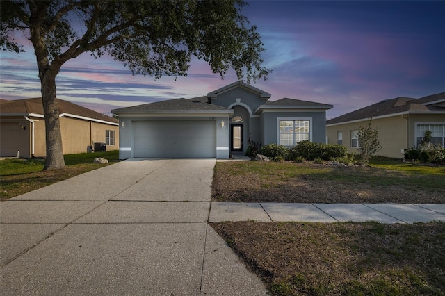 15159 Durango Cir, Brooksville, FL 34604 - ranch-style home featuring stucco siding, a garage, driveway, and a front lawn