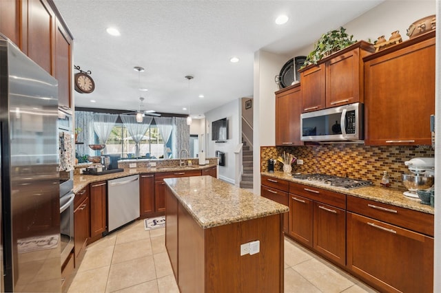 3243 Stonegate Falls Dr, Land O Lakes, FL 34638 - kitchen featuring appliances with stainless steel finishes, a sink, a kitchen island, a peninsula, and backsplash