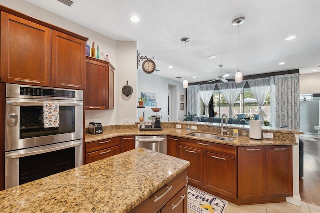 3243 Stonegate Falls Dr, Land O Lakes, FL 34638 - kitchen featuring a sink, appliances with stainless steel finishes, light stone countertops, decorative light fixtures, and a peninsula