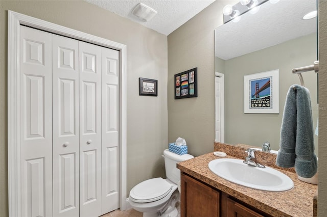 3243 Stonegate Falls Dr, Land O Lakes, FL 34638 - bathroom featuring a closet, toilet, vanity, and a textured ceiling