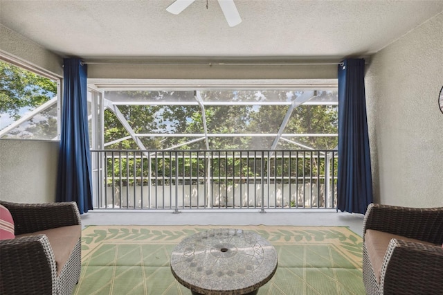 3243 Stonegate Falls Dr, Land O Lakes, FL 34638 - living area featuring a textured wall, a textured ceiling, ceiling fan, and a sunroom