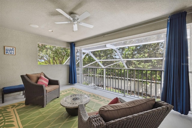 3243 Stonegate Falls Dr, Land O Lakes, FL 34638 - living room featuring a textured wall, a sunroom, a ceiling fan, and a textured ceiling