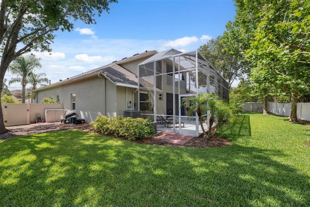 3243 Stonegate Falls Dr, Land O Lakes, FL 34638 - rear view of house featuring a patio area, stucco siding, and glass enclosure
