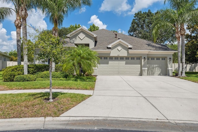 3243 Stonegate Falls Dr, Land O Lakes, FL 34638 - view of front of home with concrete driveway, a garage, stucco siding, and a shingled roof