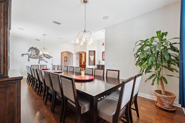 3243 Stonegate Falls Dr, Land O Lakes, FL 34638 - dining room with arched walkways, a chandelier, dark wood-style flooring, and baseboards