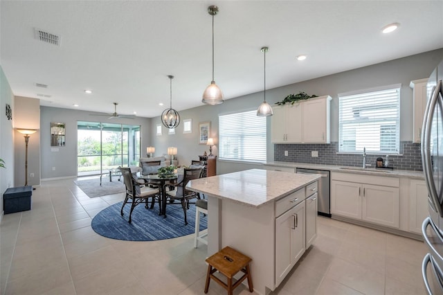 8431 Ocean Tides Cv, Parrish, FL 34219 - kitchen featuring stainless steel appliances, a sink, open floor plan, decorative backsplash, and a kitchen island