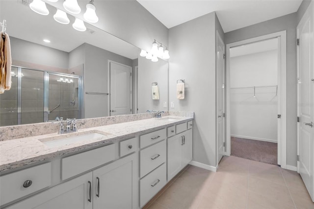 8431 Ocean Tides Cv, Parrish, FL 34219 - bathroom featuring a stall shower, double vanity, tile patterned floors, baseboards, and a spacious closet