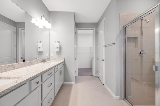 8431 Ocean Tides Cv, Parrish, FL 34219 - full bathroom featuring a stall shower, double vanity, tile patterned flooring, and a walk in closet