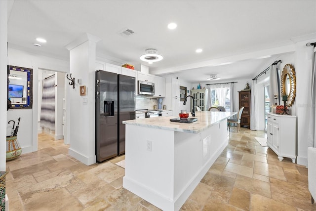 5340 Pilots Pl, New Port Richey, FL 34652 - kitchen featuring stainless steel appliances, stone tile floors, white cabinets, a kitchen island with sink, and recessed lighting