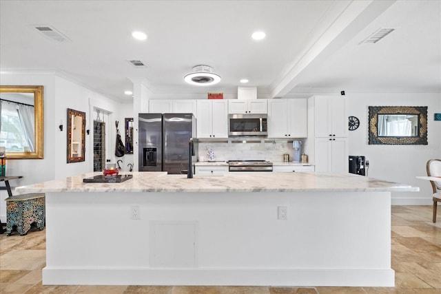 5340 Pilots Pl, New Port Richey, FL 34652 - kitchen featuring stainless steel appliances, white cabinetry, a large island with sink, tasteful backsplash, and light stone counters