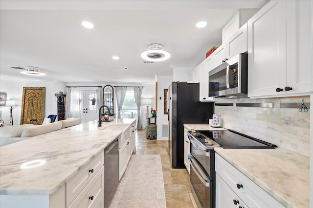 5340 Pilots Pl, New Port Richey, FL 34652 - kitchen with stainless steel appliances, tasteful backsplash, a sink, light stone finish flooring, and open floor plan