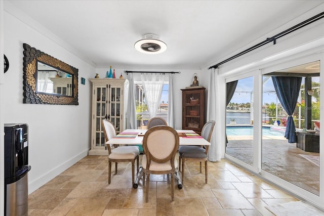 5340 Pilots Pl, New Port Richey, FL 34652 - dining room featuring stone tile floors, healthy amount of natural light, baseboards, and a water view