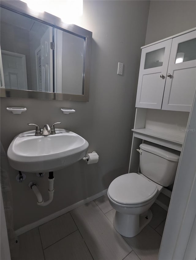 2004 Culberson Ave, Dunedin, FL 34698 - bathroom featuring toilet, a sink, and baseboards