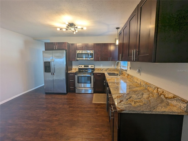 2004 Culberson Ave, Dunedin, FL 34698 - kitchen with stainless steel appliances, a sink, dark brown cabinetry, dark wood finished floors, and light stone counters