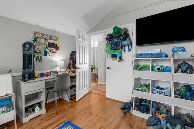home office with wood finished floors and vaulted ceiling