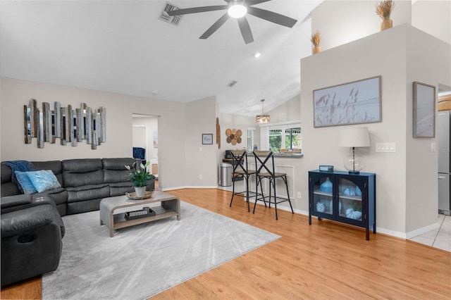 living area featuring a ceiling fan, lofted ceiling, light wood-style floors, and baseboards