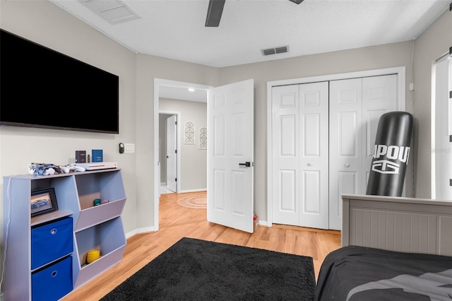 bedroom featuring light wood-style flooring, a closet, baseboards, and a ceiling fan