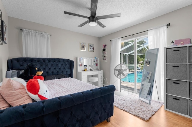 bedroom with wood finished floors, access to exterior, a textured ceiling, and a ceiling fan