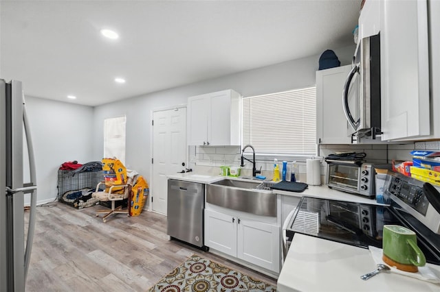 4737 6th St, Zephyrhills, FL 33542 - kitchen featuring stainless steel appliances, a sink, light countertops, light wood-type flooring, and recessed lighting