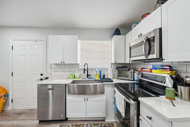 4737 6th St, Zephyrhills, FL 33542 - kitchen with stainless steel appliances, a sink, backsplash, and light wood finished floors