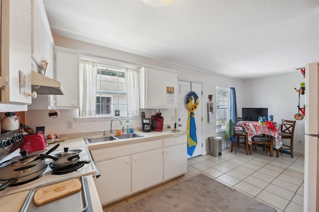 4737 6th St, Zephyrhills, FL 33542 - kitchen featuring a sink, under cabinet range hood, white range with gas cooktop, light tile patterned flooring, and white cabinets