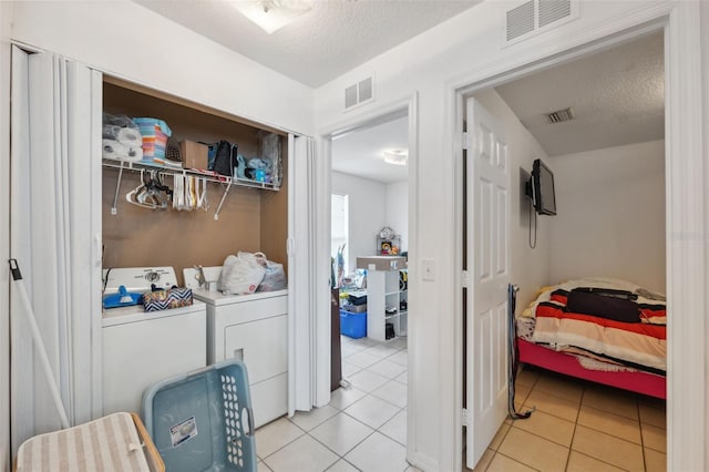 4737 6th St, Zephyrhills, FL 33542 - laundry area featuring separate washer and dryer, a textured ceiling, and light tile patterned flooring