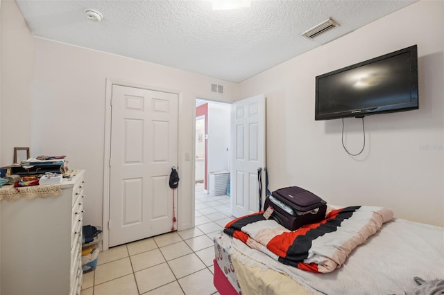 4737 6th St, Zephyrhills, FL 33542 - bedroom featuring light tile patterned flooring and a textured ceiling
