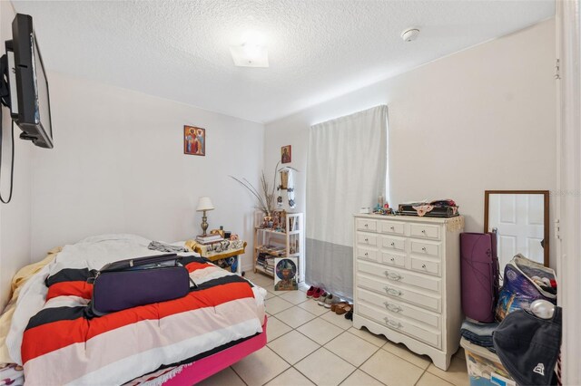 4737 6th St, Zephyrhills, FL 33542 - bedroom with a textured ceiling and light tile patterned flooring
