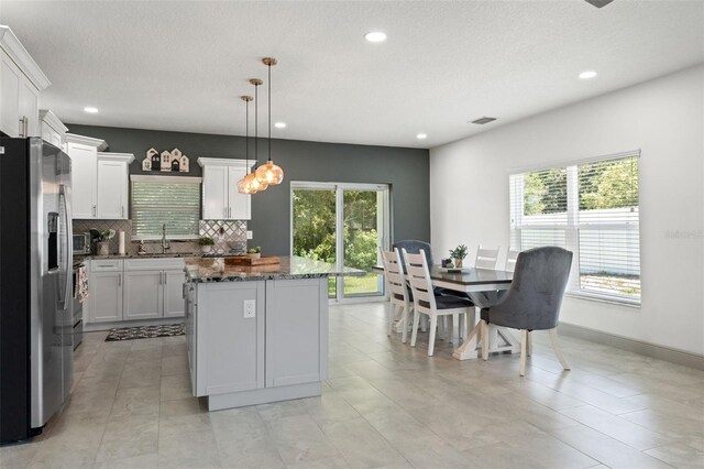 5328 Baldock Ave, Spring Hill, FL 34608 - kitchen featuring stainless steel refrigerator with ice dispenser, a center island, plenty of natural light, backsplash, and recessed lighting