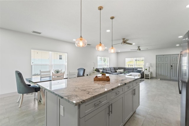 5328 Baldock Ave, Spring Hill, FL 34608 - kitchen featuring a kitchen island, freestanding refrigerator, ceiling fan, light stone countertops, and recessed lighting