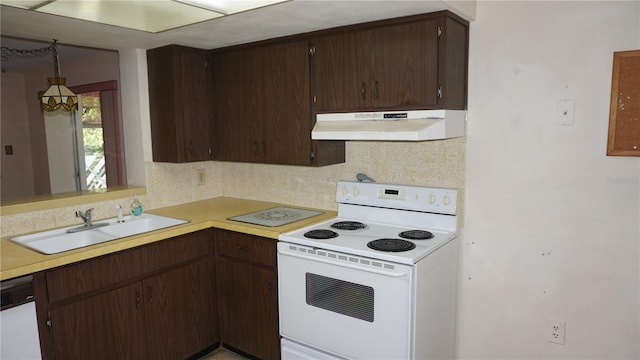 5636 Dolores Dr, Holiday, FL 34690 - kitchen with under cabinet range hood, white appliances, decorative backsplash, and light countertops