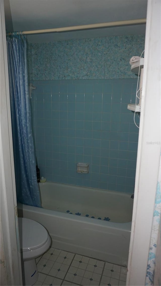 5636 Dolores Dr, Holiday, FL 34690 - bathroom featuring tile patterned flooring, shower / bathtub combination with curtain, and toilet