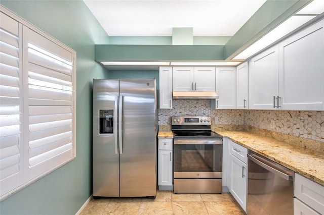 9212 Estrada Pl, New Port Richey, FL 34655 - kitchen with stainless steel appliances, under cabinet range hood, tasteful backsplash, and light stone counters