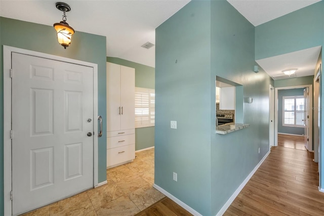 9212 Estrada Pl, New Port Richey, FL 34655 - foyer with baseboards and light wood-style flooring