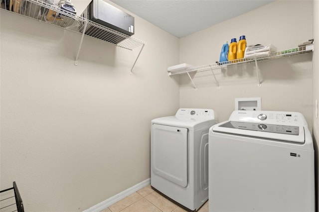 12055 Colony Lakes Blvd, New Port Richey, FL 34654 - laundry room with washer and dryer, baseboards, and light tile patterned floors