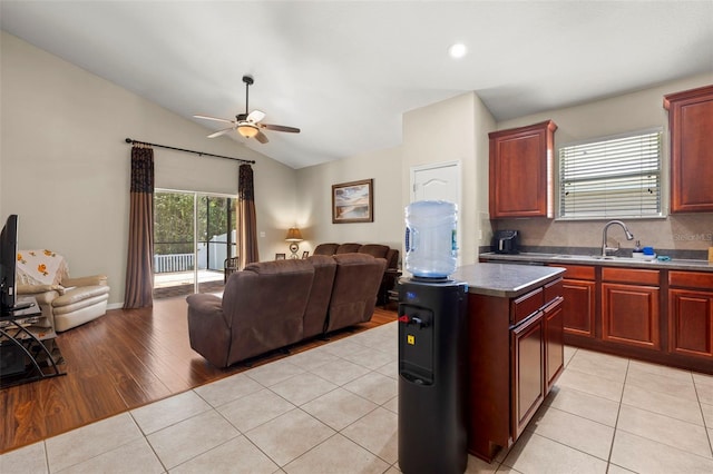 12055 Colony Lakes Blvd, New Port Richey, FL 34654 - kitchen with a sink, open floor plan, ceiling fan, reddish brown cabinets, and vaulted ceiling