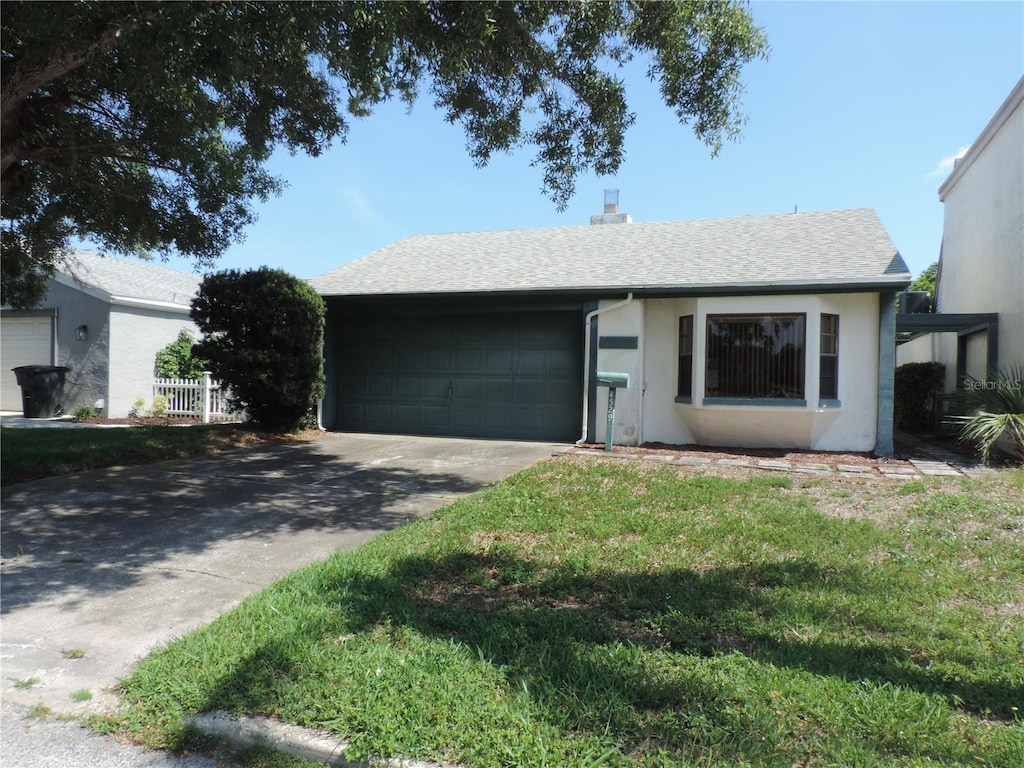 4529 Keelboat Pl, New Port Richey, FL 34652 - ranch-style home with an attached garage, driveway, stucco siding, a chimney, and a shingled roof