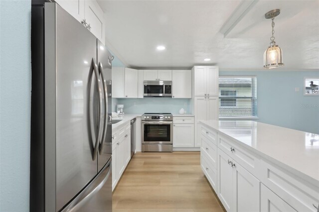 4942 Blue Heron Dr, New Port Richey, FL 34652 - kitchen featuring stainless steel appliances, light countertops, white cabinets, decorative light fixtures, and recessed lighting