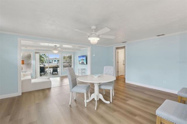 4942 Blue Heron Dr, New Port Richey, FL 34652 - dining room with a ceiling fan, baseboards, light wood-style flooring, and crown molding