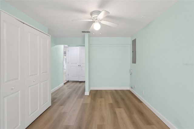 4942 Blue Heron Dr, New Port Richey, FL 34652 - unfurnished bedroom featuring light wood-style floors, baseboards, electric panel, a closet, and a ceiling fan