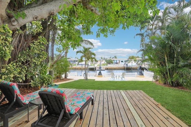 4942 Blue Heron Dr, New Port Richey, FL 34652 - wooden deck featuring a water view, a lawn, and a boat dock
